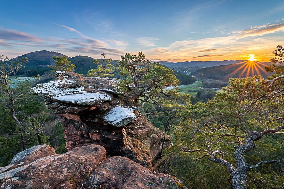 Sonnenuntergang am Sprinzelfelsen, mit zarten Schneehauch über dem Sandsteinfelsen. Sonnenstern