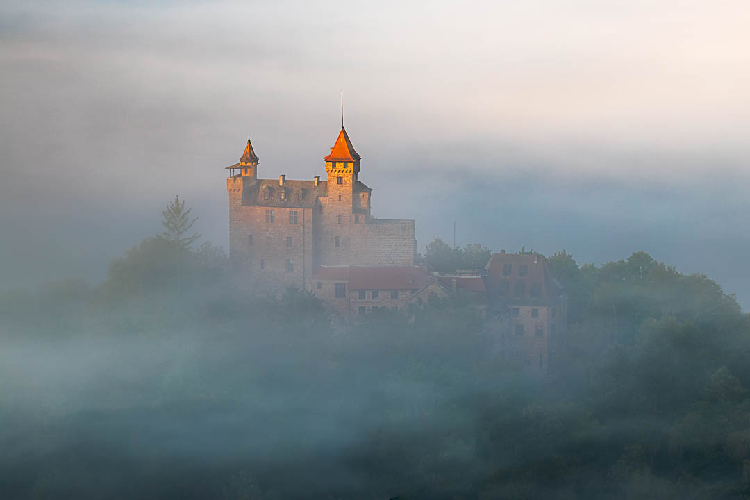 Herbst an der Burg Berwartstein. Fette Nebelschwarten umgarnen die Burg und die Sonne beleuchtet den Turm