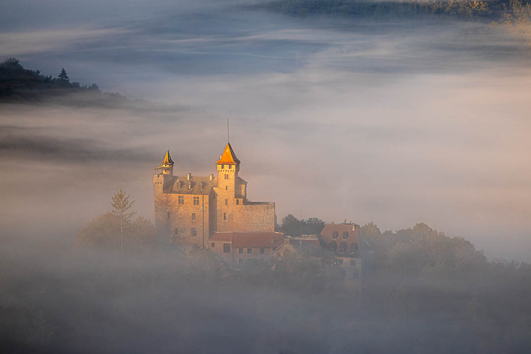 Herbst an der Burg Berwartstein. Fette Nebelschwarten umgarnen die Burg und die Sonne beleuchtet den Turm
